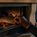 Clapet de cheminée fonctionnement : main règle le clapet pour chauffer sans gaspiller